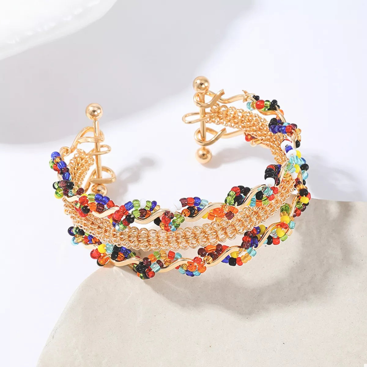 Gold open cuff bracelet with three rows of chain and multicolor bead details