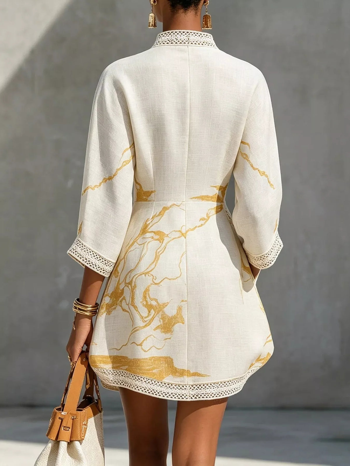 White relaxed mini dress with lace-trim V-back neckline and gold abstract print