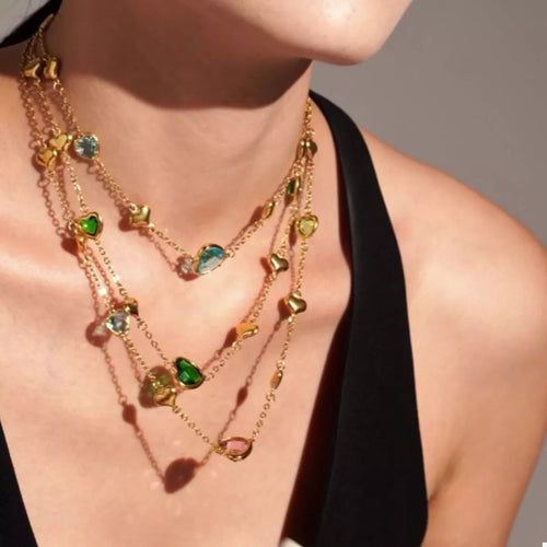 Gold-plated heart necklace with green and blue glass heart charms on chains