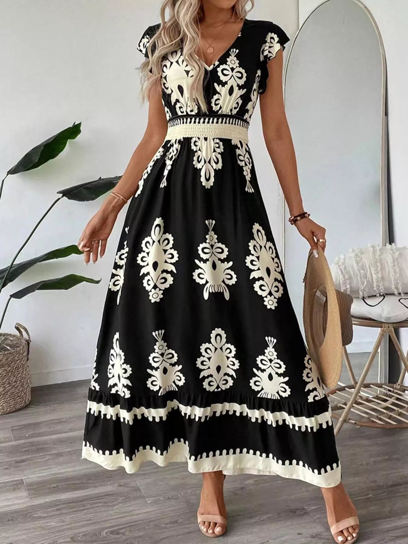 Black printed V-neck maxi dress with short sleeves, ruffled hem and gathered waist.