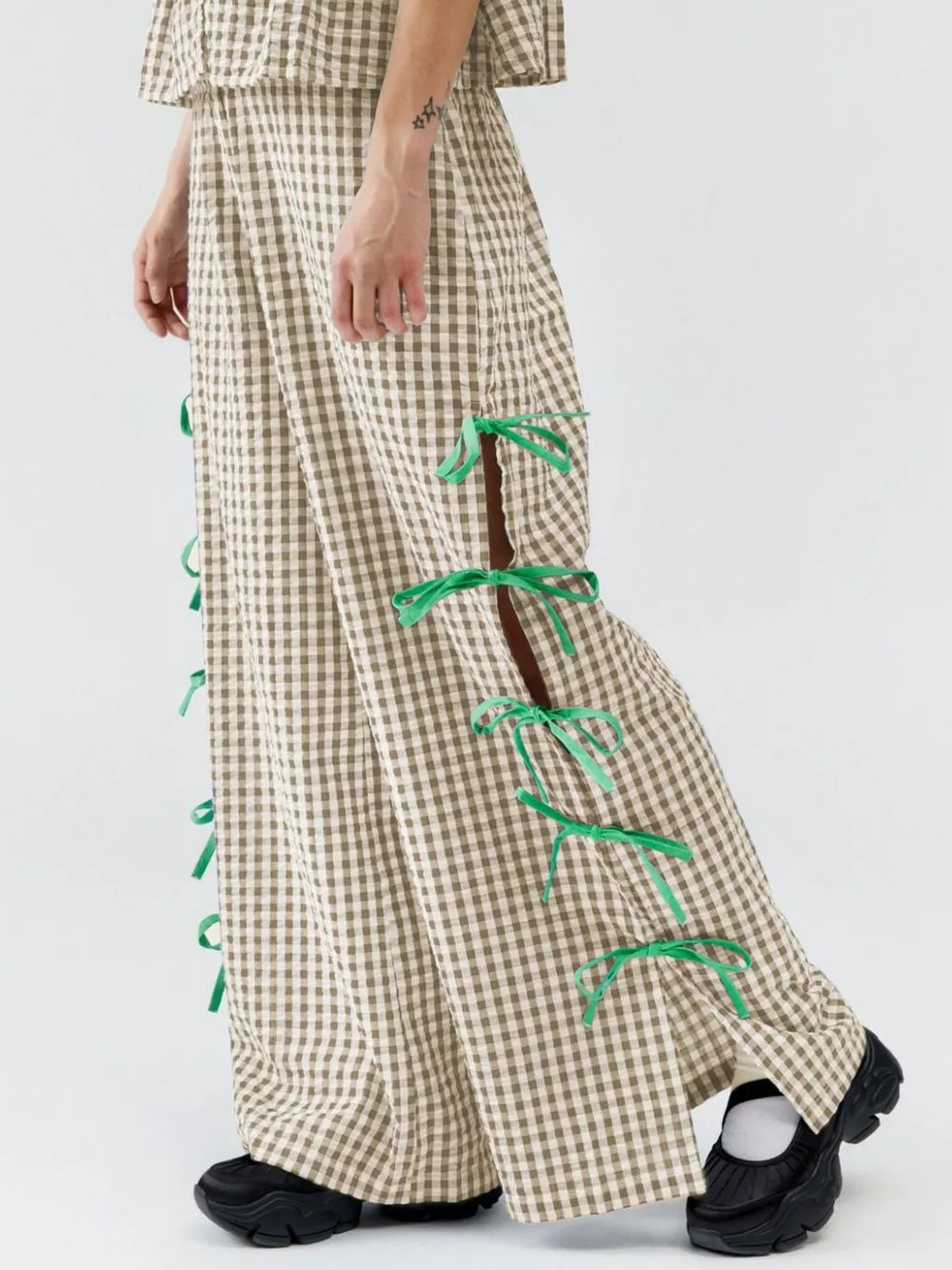 Tan gingham plaid pants with green side ribbon ties, full length view