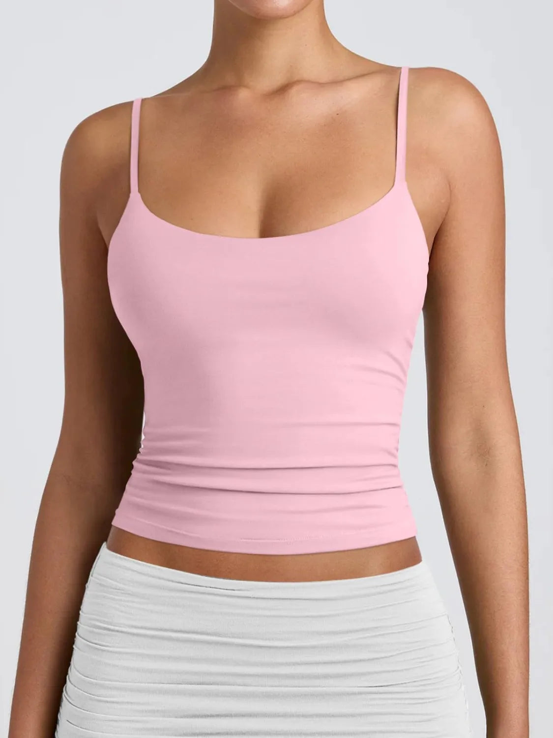 Scoop neck cami in blush pink with spaghetti straps and fitted ruched hem.