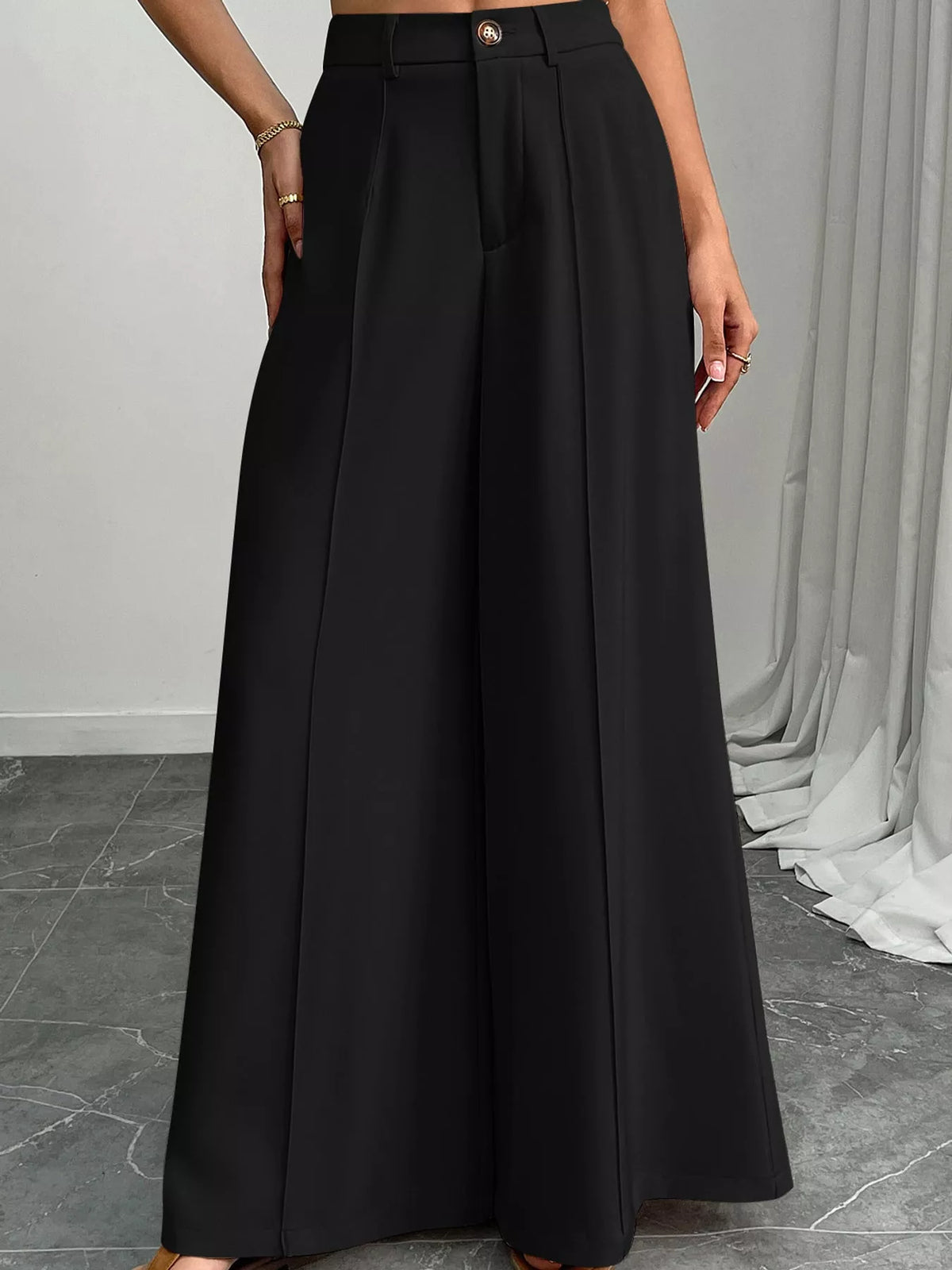 Black high-waisted wide-leg relaxed pants with pleated front and button closure