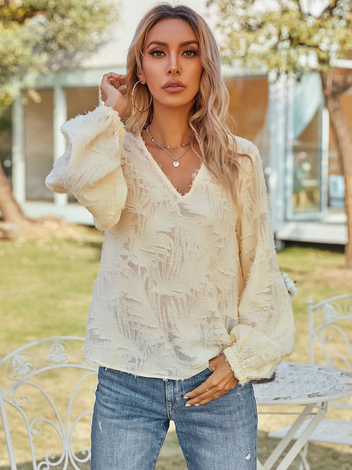 Cream V-neck long sleeve blouse with ruffled puff sleeves, textured front