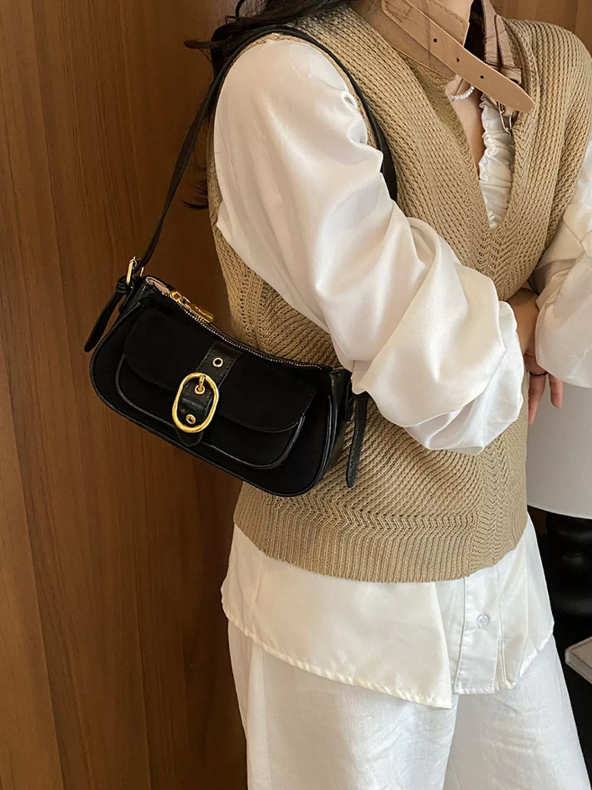 Black suede flap shoulder bag with gold-tone buckle detail and slim shoulder strap