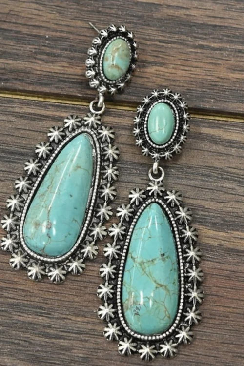 Turquoise teardrop earrings with starburst silver-tone settings and dangling oval