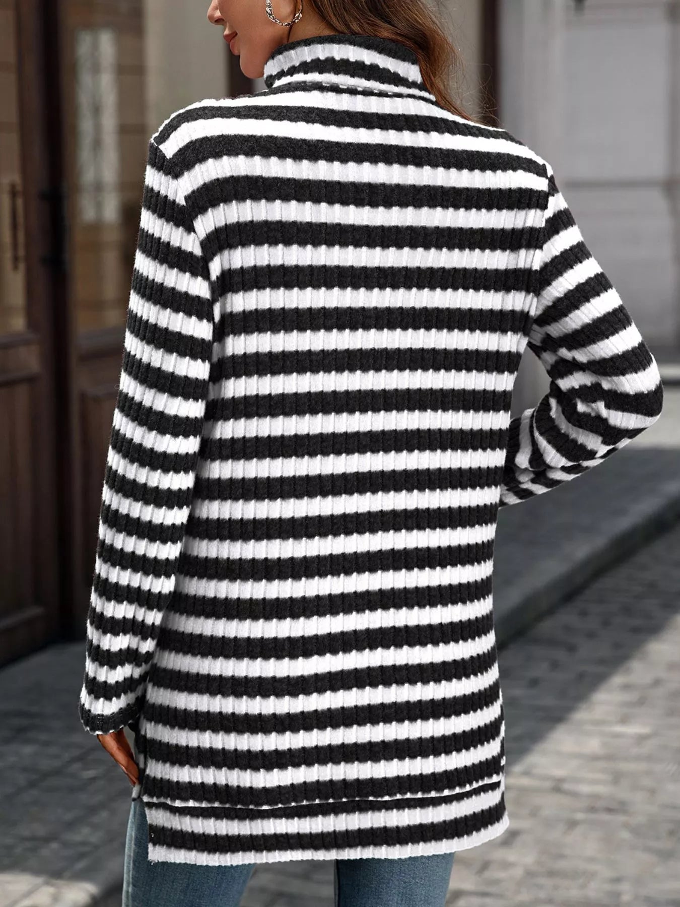 Black and white striped knit turtleneck long-sleeve top, back view with ribbed cuffs.