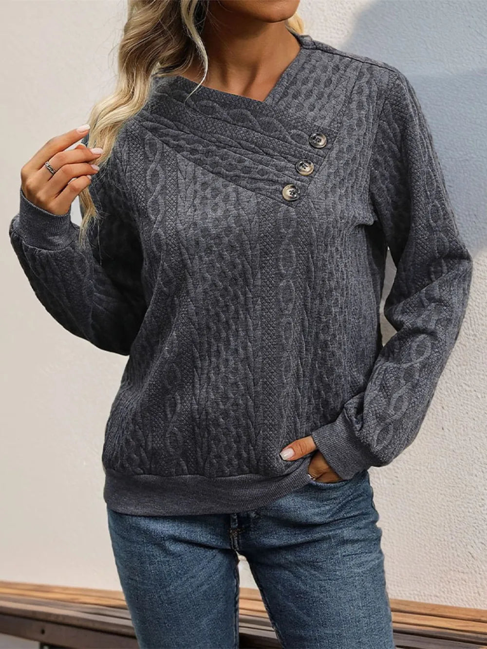 Dark gray long sleeve sweatshirt with crossover neckline and decorative button detail