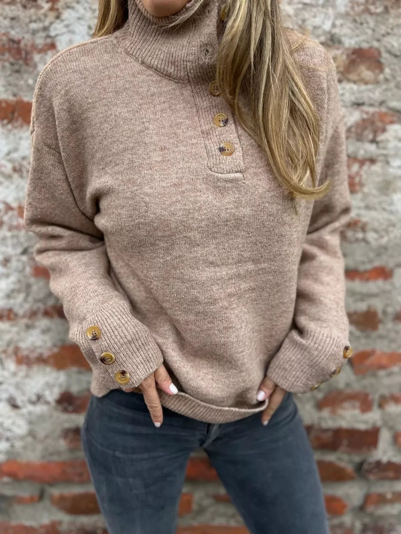 Beige knit turtleneck sweater with button placket and ribbed cuffs with gold buttons