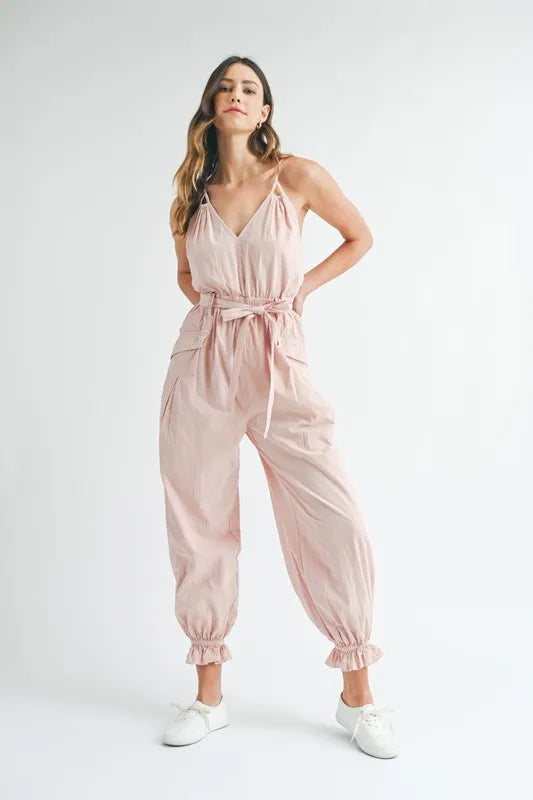 Pink spaghetti strap belted jumpsuit with loose legs and gathered ankle cuffs