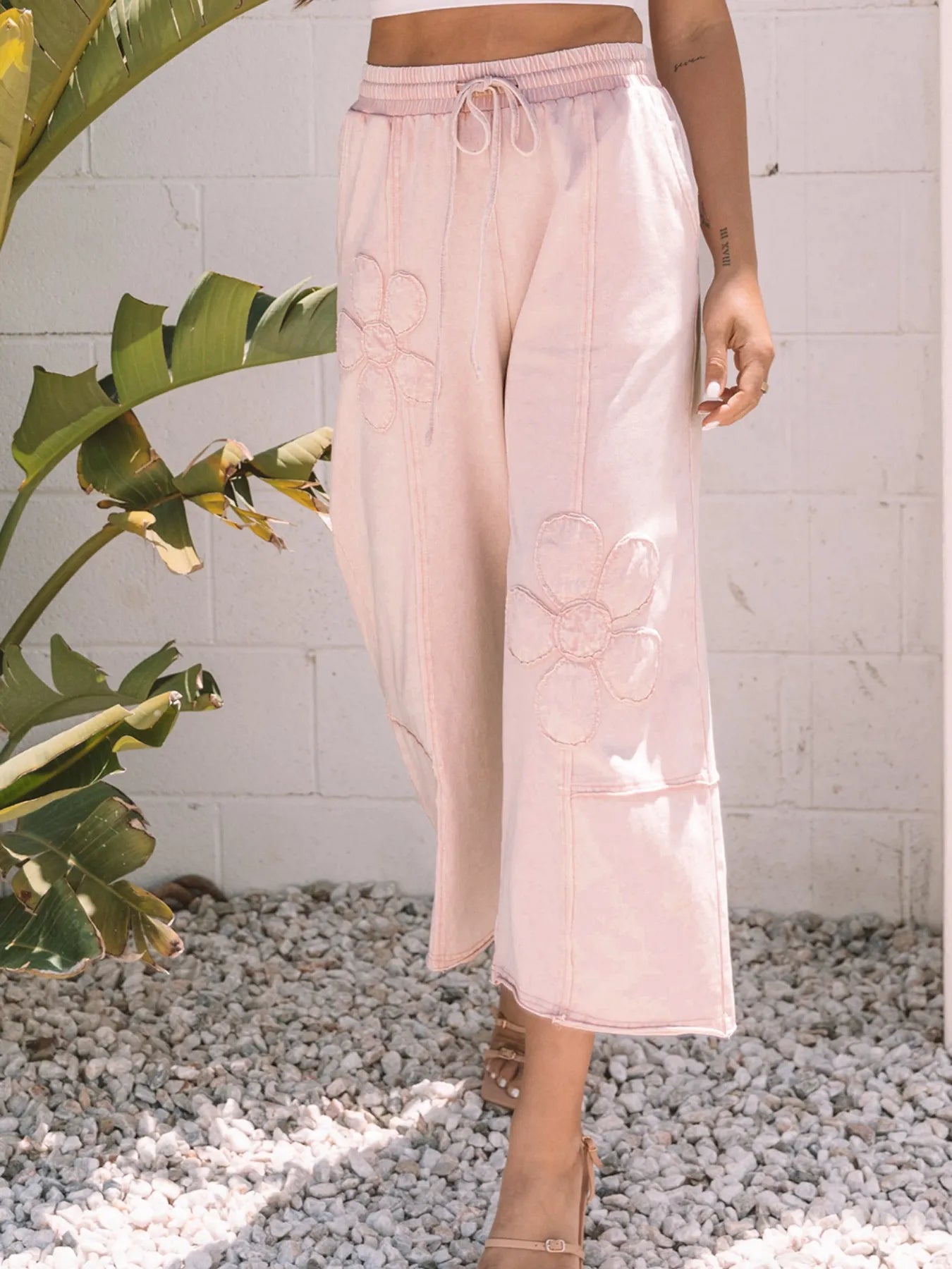 Floral blush pink crop pants with drawstring waistband and allover flower embroidery