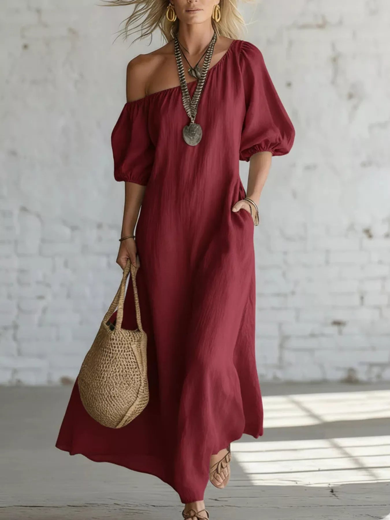 Burgundy one-shoulder maxi dress with puff sleeves and flowing draped skirt