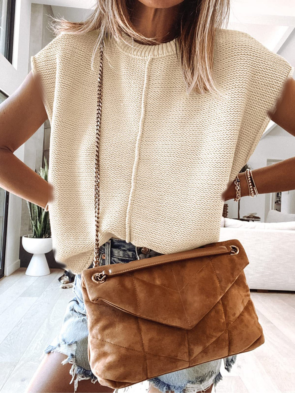 Cap-sleeve sweater vest in light ivory knit with ribbed crew neckline and vertical seam