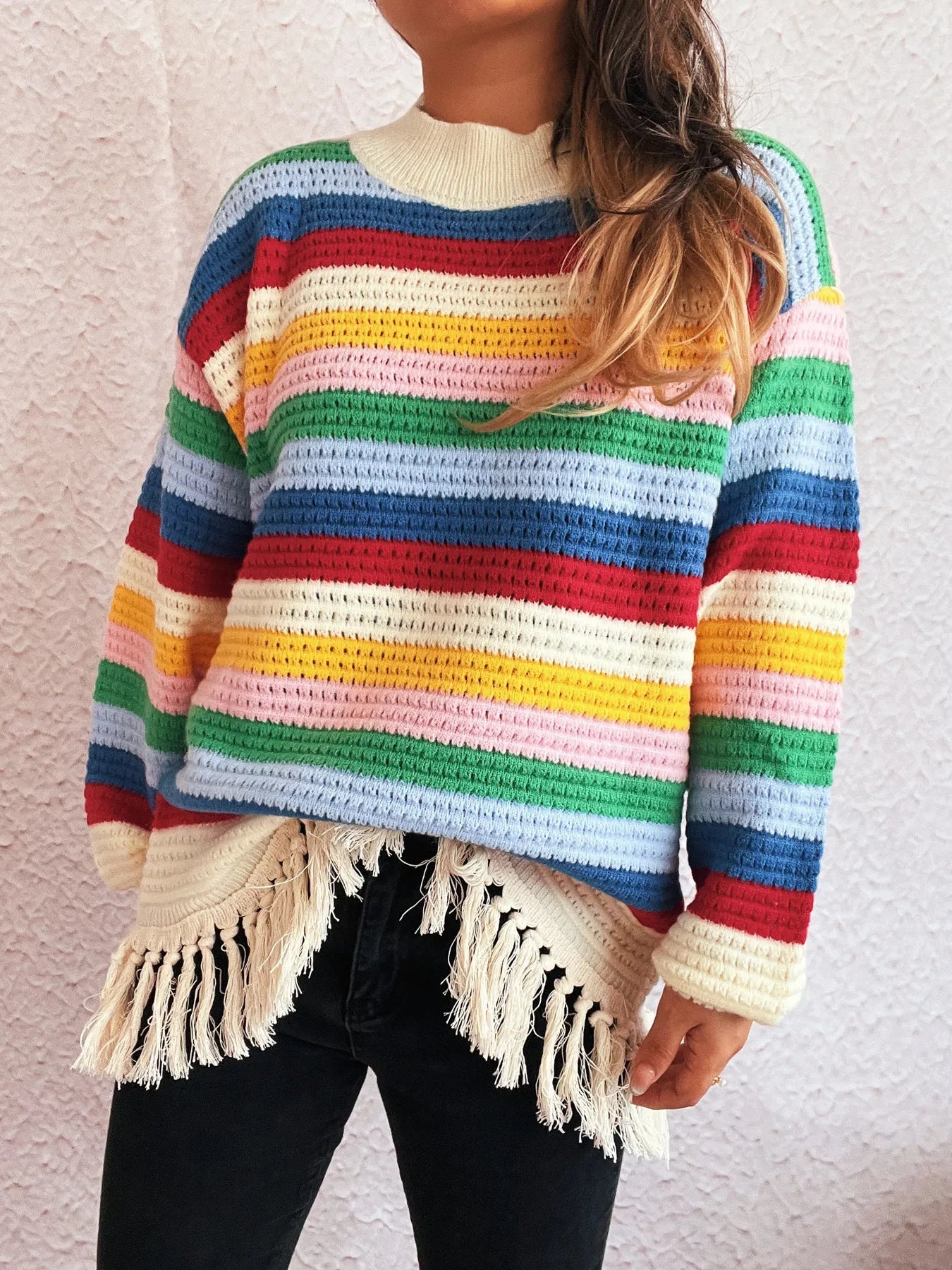 Rainbow striped long sleeve sweater with cream neckline and tassel fringe hem