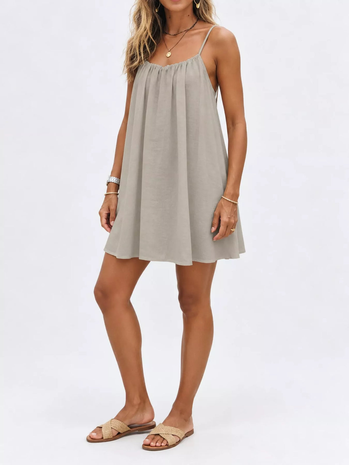 Gray backless spaghetti strap ruched mini dress with gathered neckline and swaying skirt