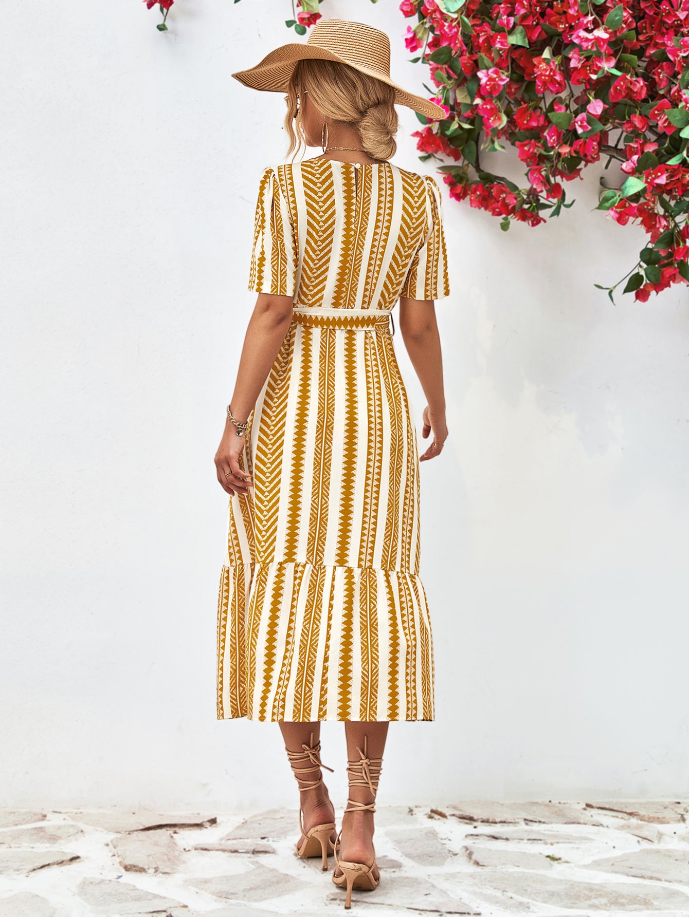 Gold striped round-neck puff sleeve dress with tied waist belt, rear view.