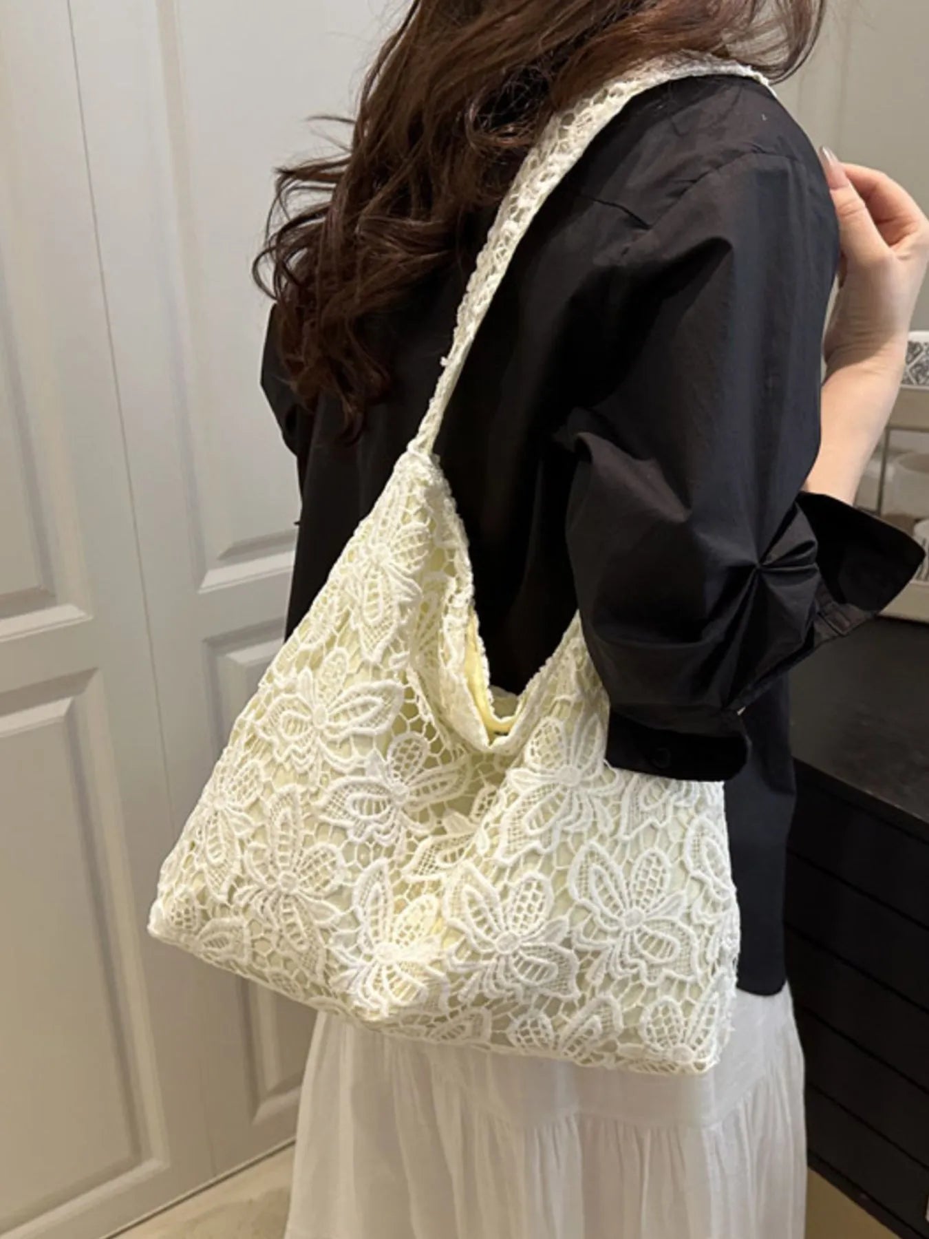 White lace shoulder bag with openwork floral pattern and short shoulder handles
