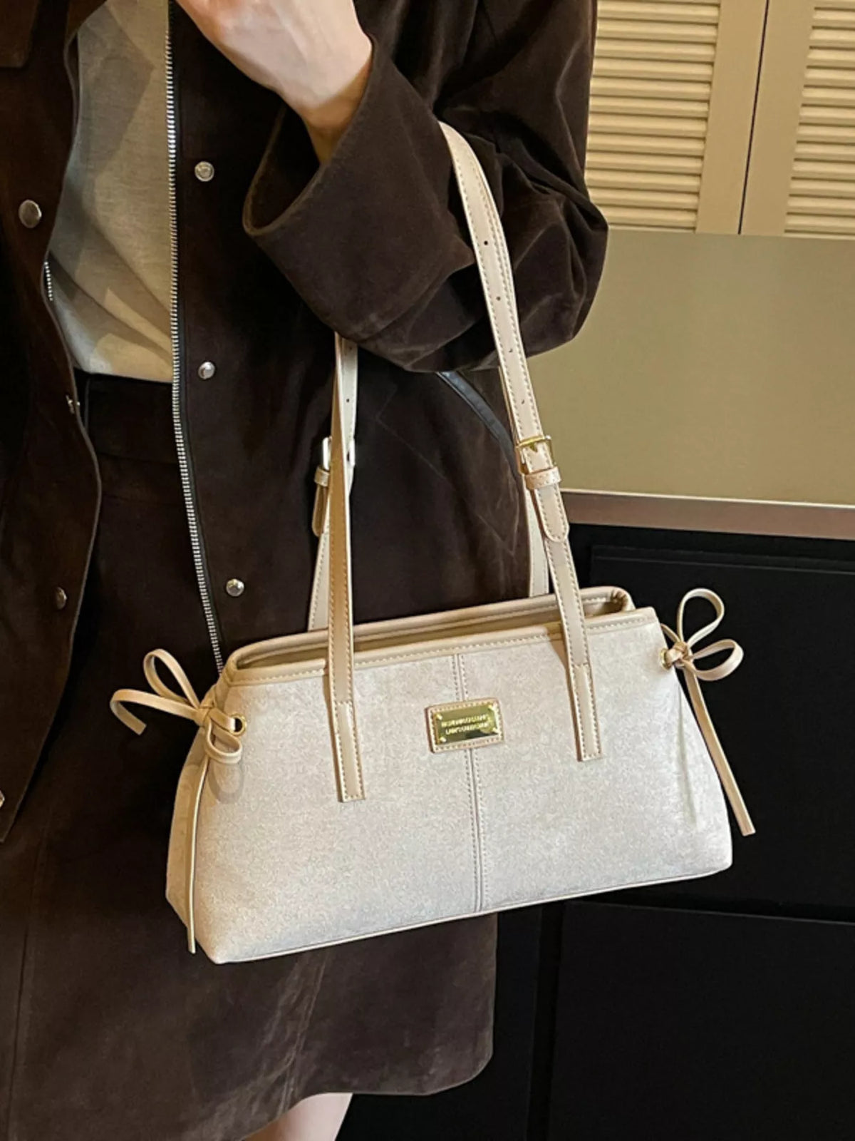 Medium suede side-tie shoulder bag in light color, with gold logo plate and side ties