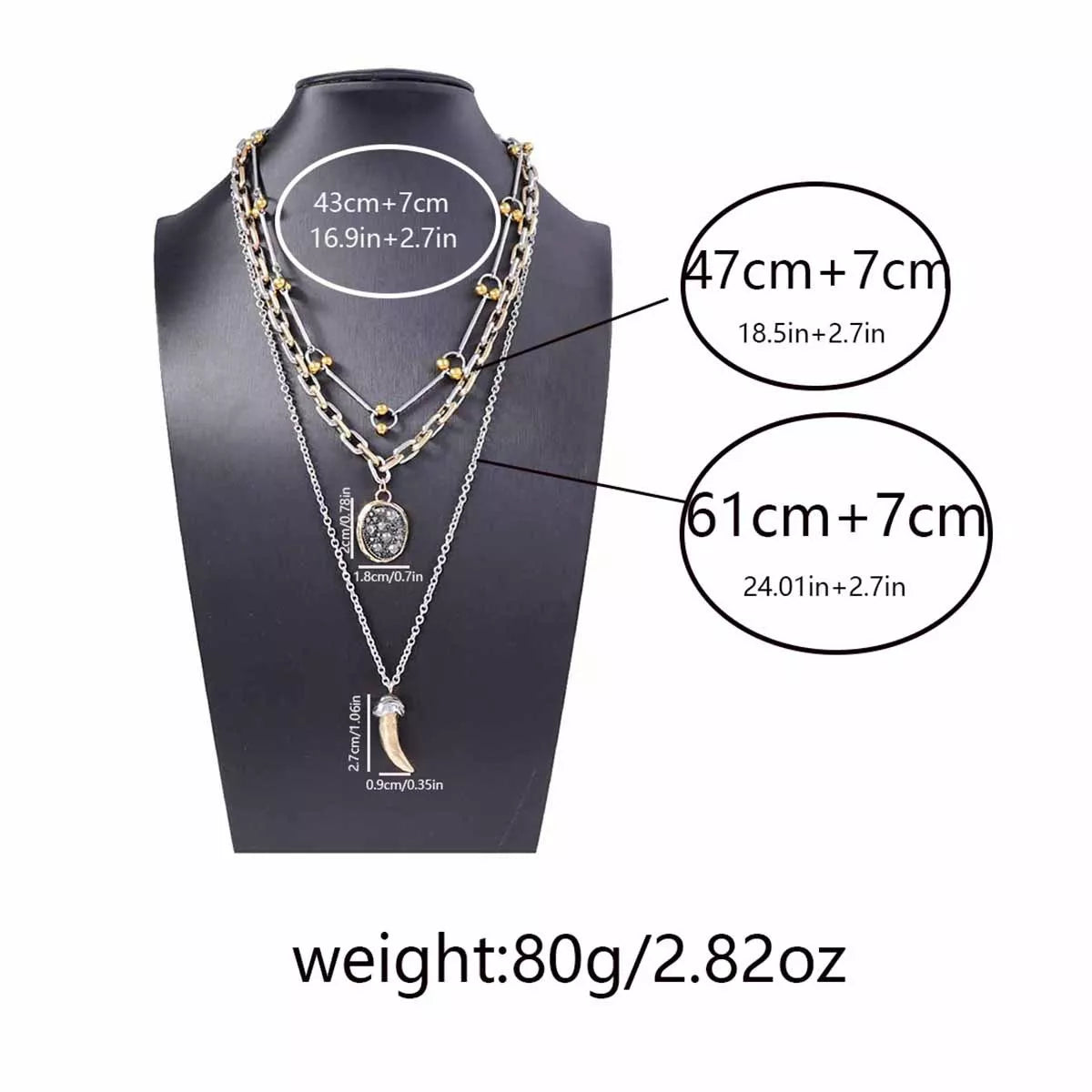 Gold plated layered necklace set on display with dark round disc and horn pendant