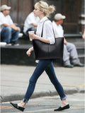 Black medium vegan leather tote bag with two top handles and open interior