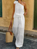 White one-shoulder top with floral embellishment and wide-leg pants set