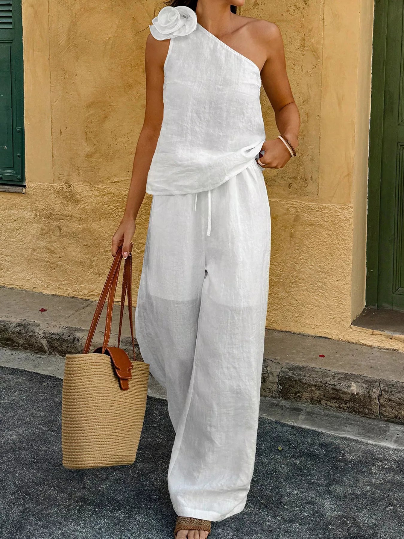 White one-shoulder top with floral embellishment and wide-leg pants set