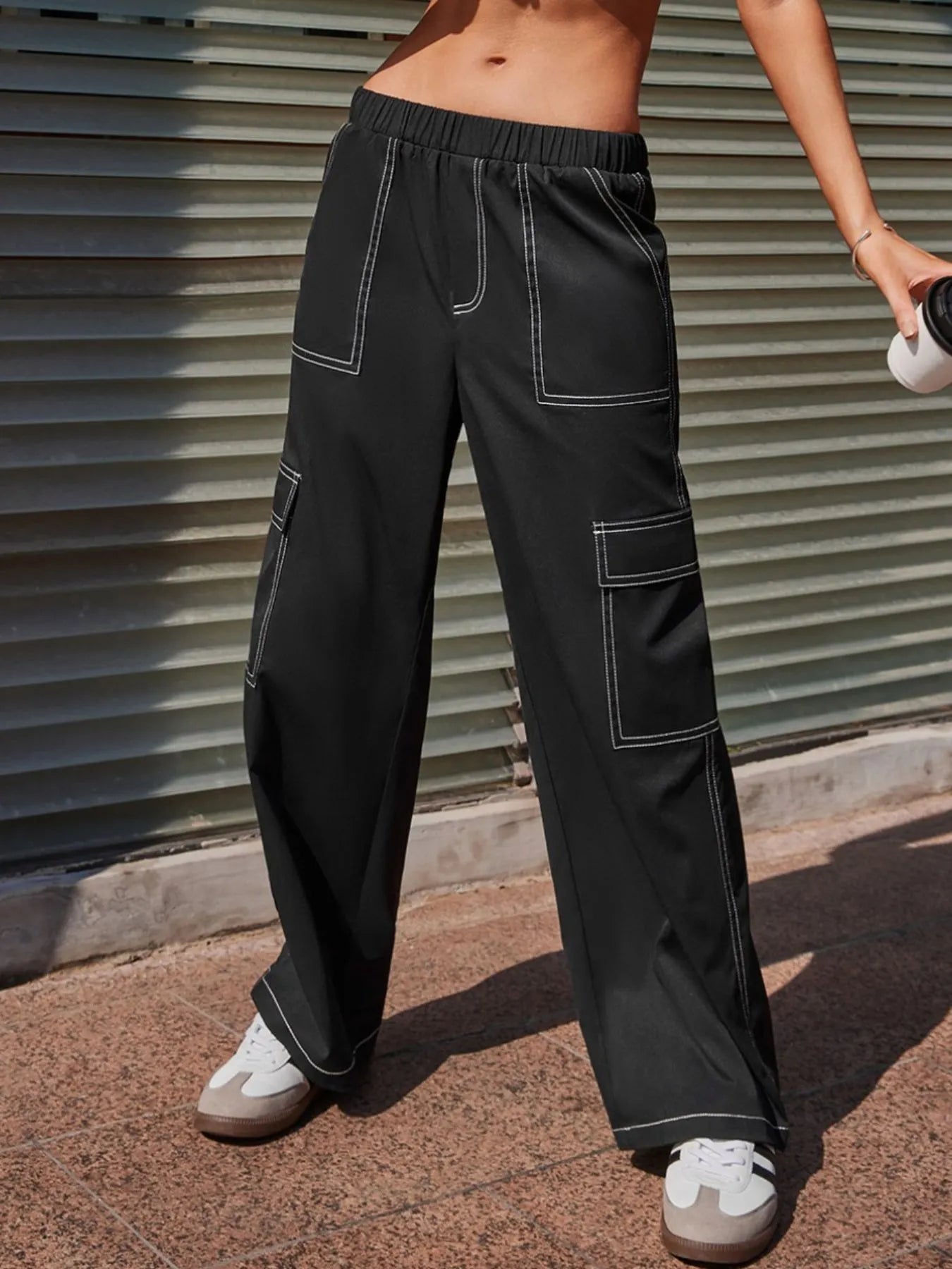 Black wide-leg pants with elastic waistband and contrast-stitched cargo pocket