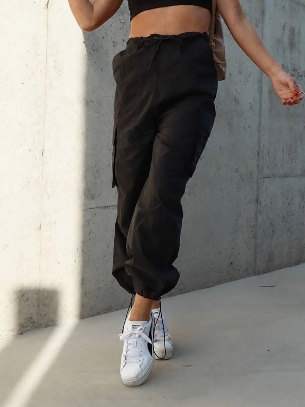 Black cargo drawstring pants with flap pockets and cuffed hems