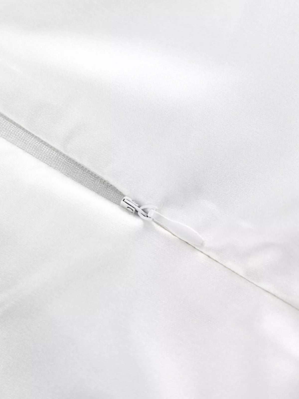 White satin skirt zipper detail with metal pull along the seam