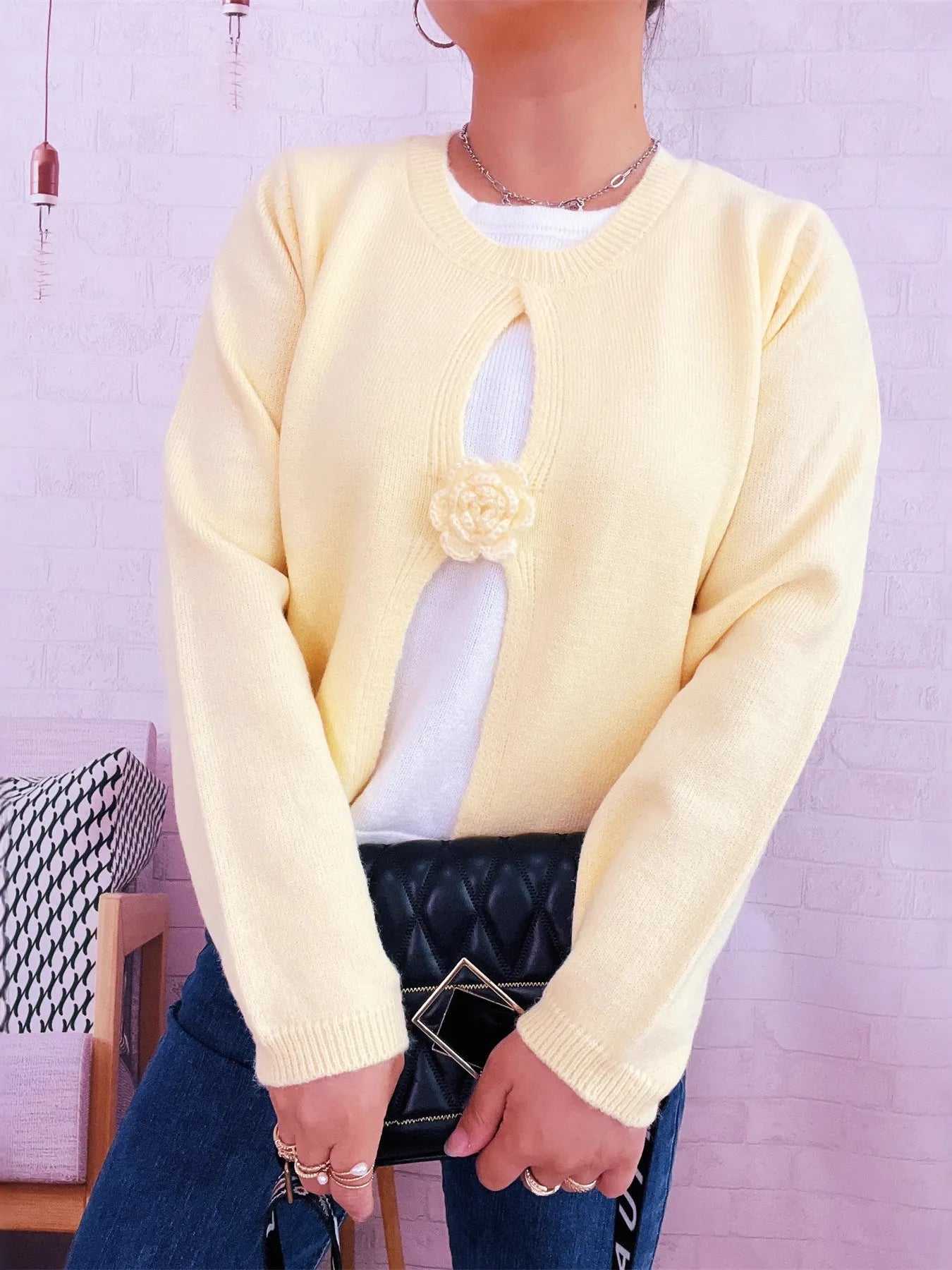Cream round-neck sweater with white contrast panel and rose-style floral appliqué