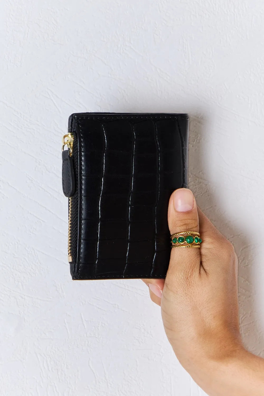 Black textured vegan leather mini wallet with gold-tone zipper and front seam details