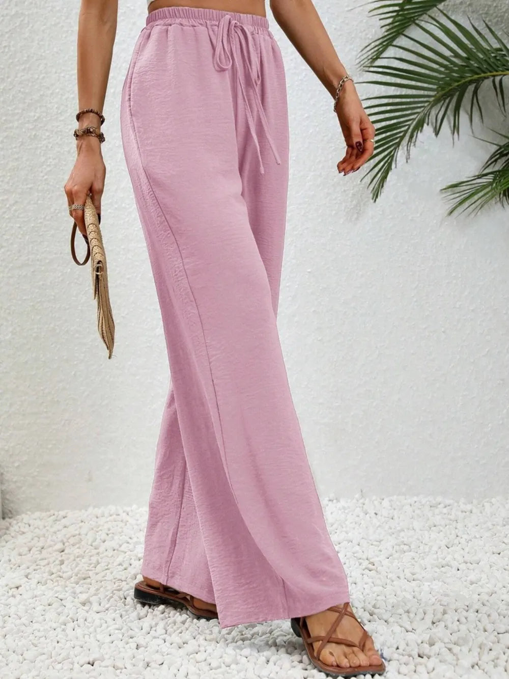 Pink wide-leg drawstring pants with elastic waistband and loose flared legs