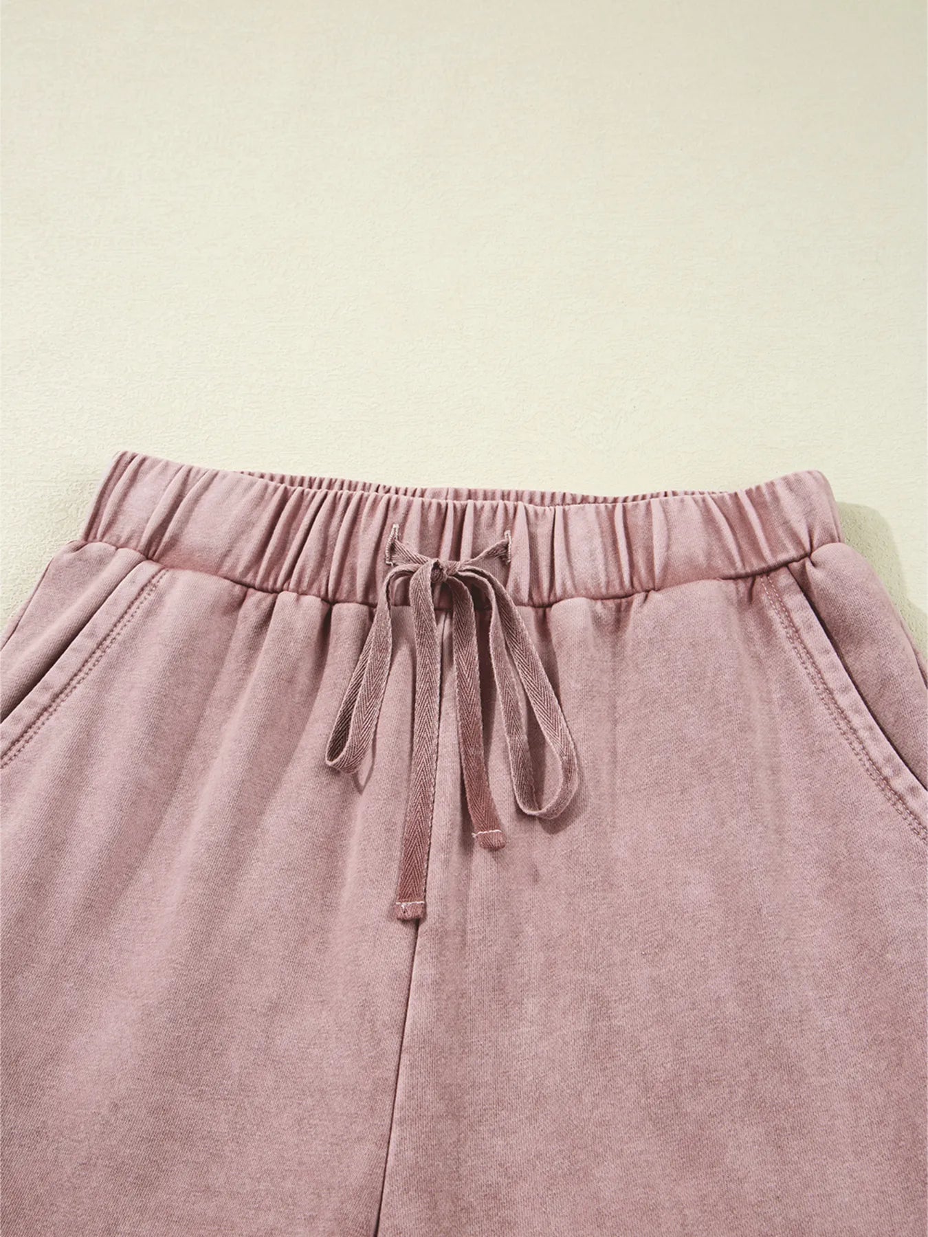 Dusty pink tiered wide-leg pants with drawstring bow tie at elastic waist