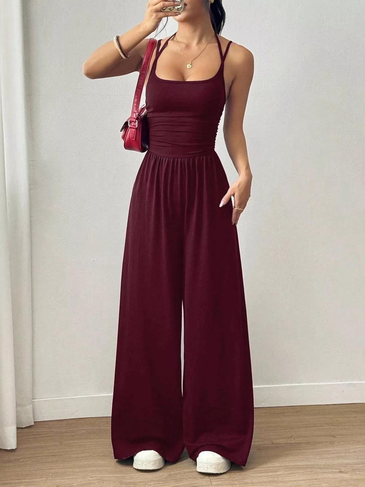 Burgundy spaghetti-strap wide-leg jumpsuit with scoop neckline and ruched bodice