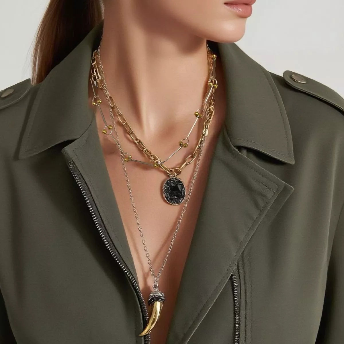 Gold plated layered chain necklace with dark round disc and horn pendant