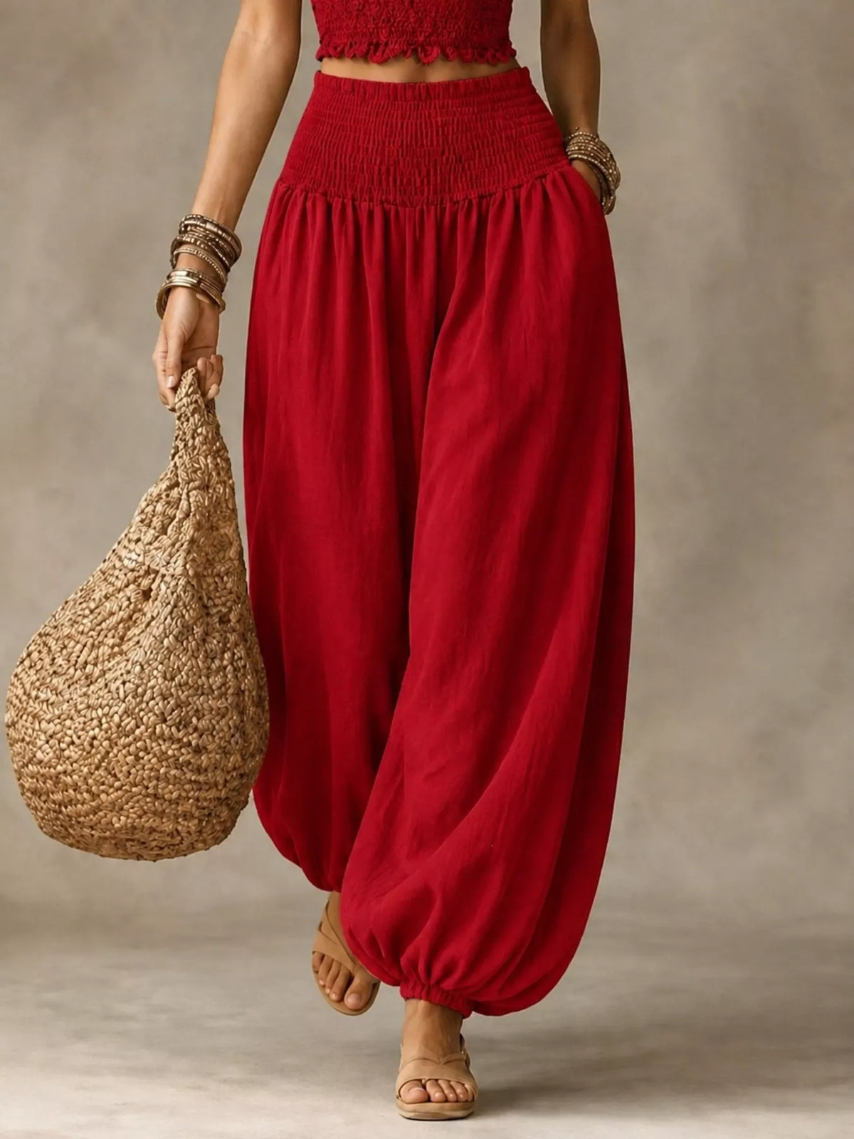 Red elastic-waist smocked harem pants with wide legs and gathered ankle cuffs