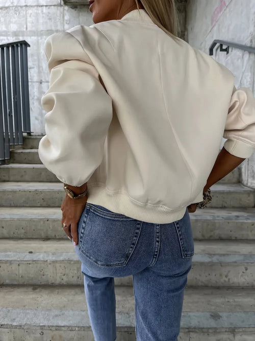 Beige dropped-shoulder jacket back view with ribbed hem and gathered sleeves.