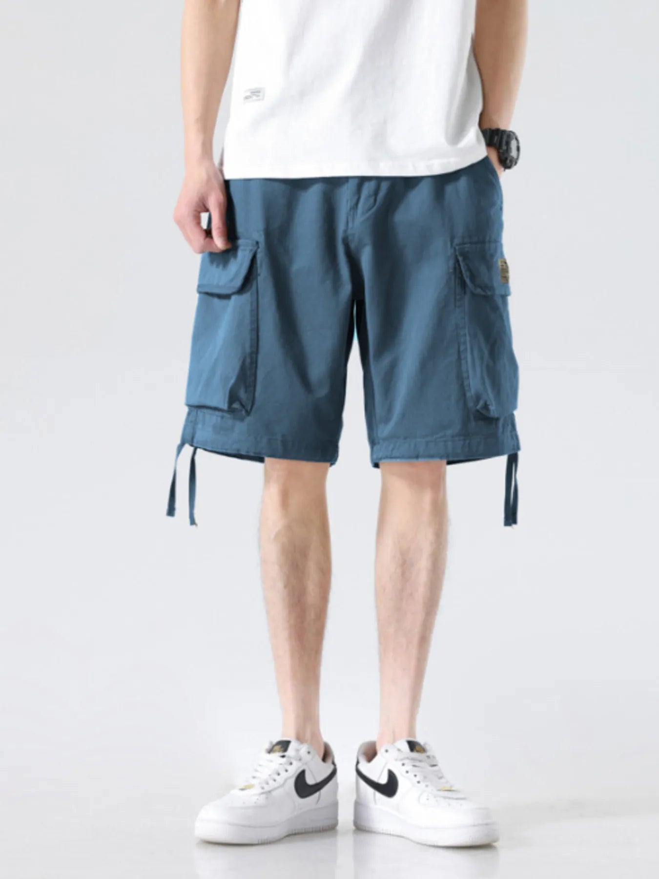 Men's blue drawstring wide-leg cargo shorts with flap cargo pockets and leg ties