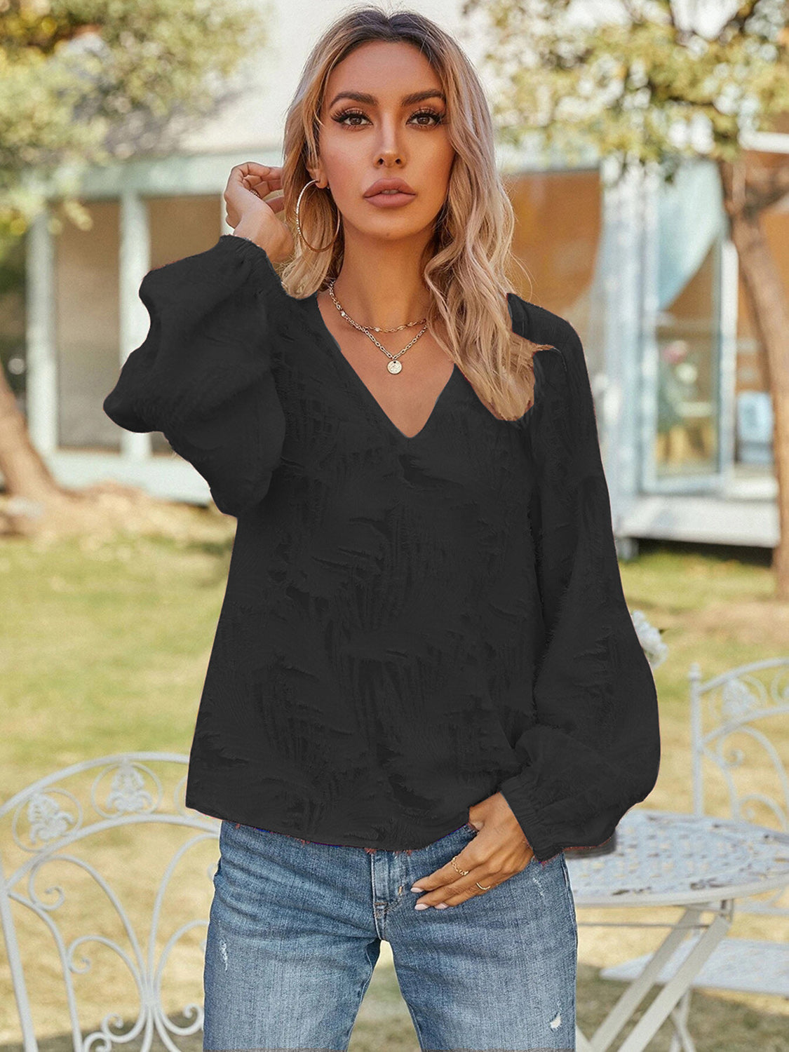 Black V-neck long sleeve blouse with puff sleeves and textured fabric