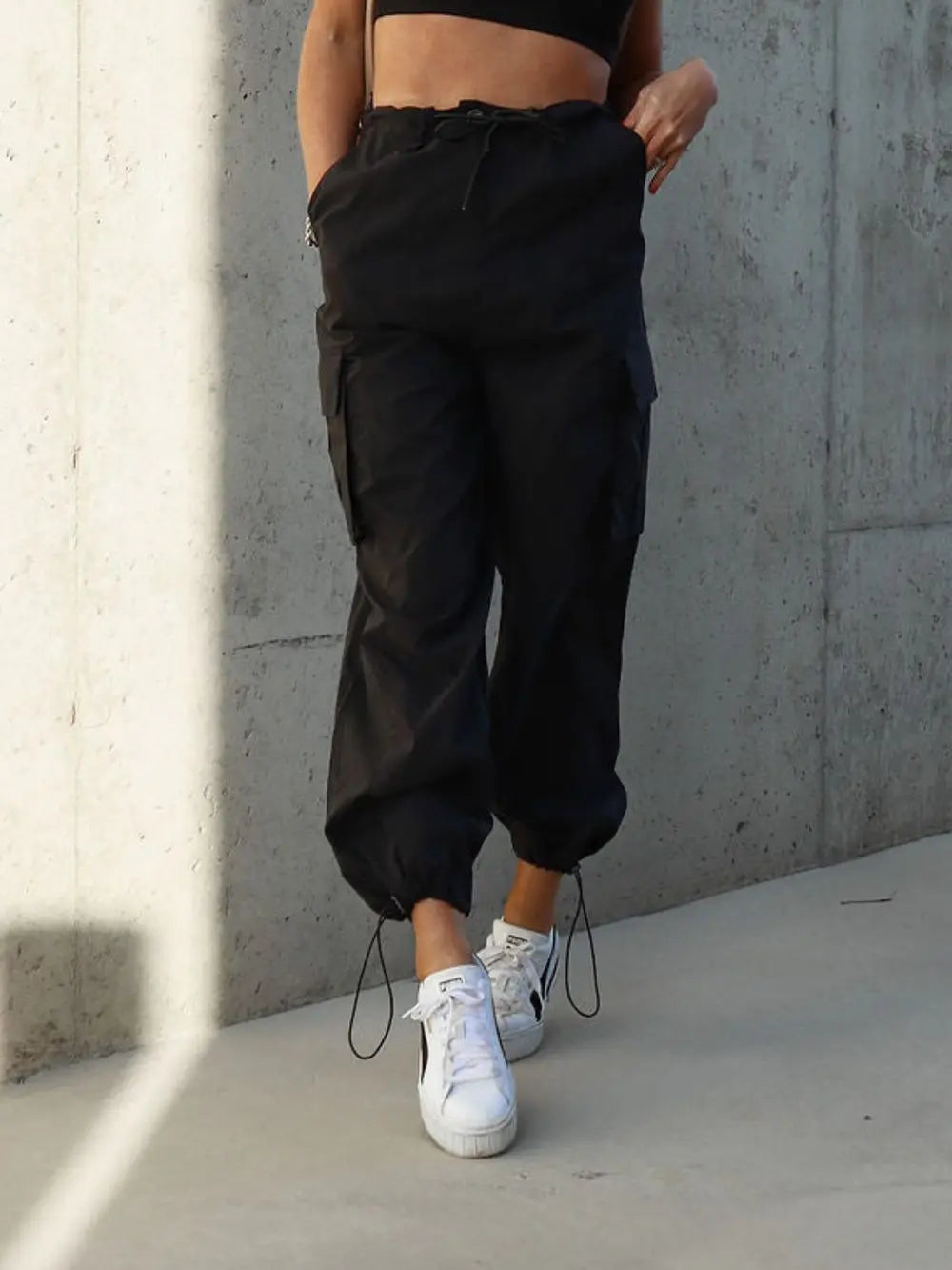 Black drawstring pants with pockets and cuffed ankles