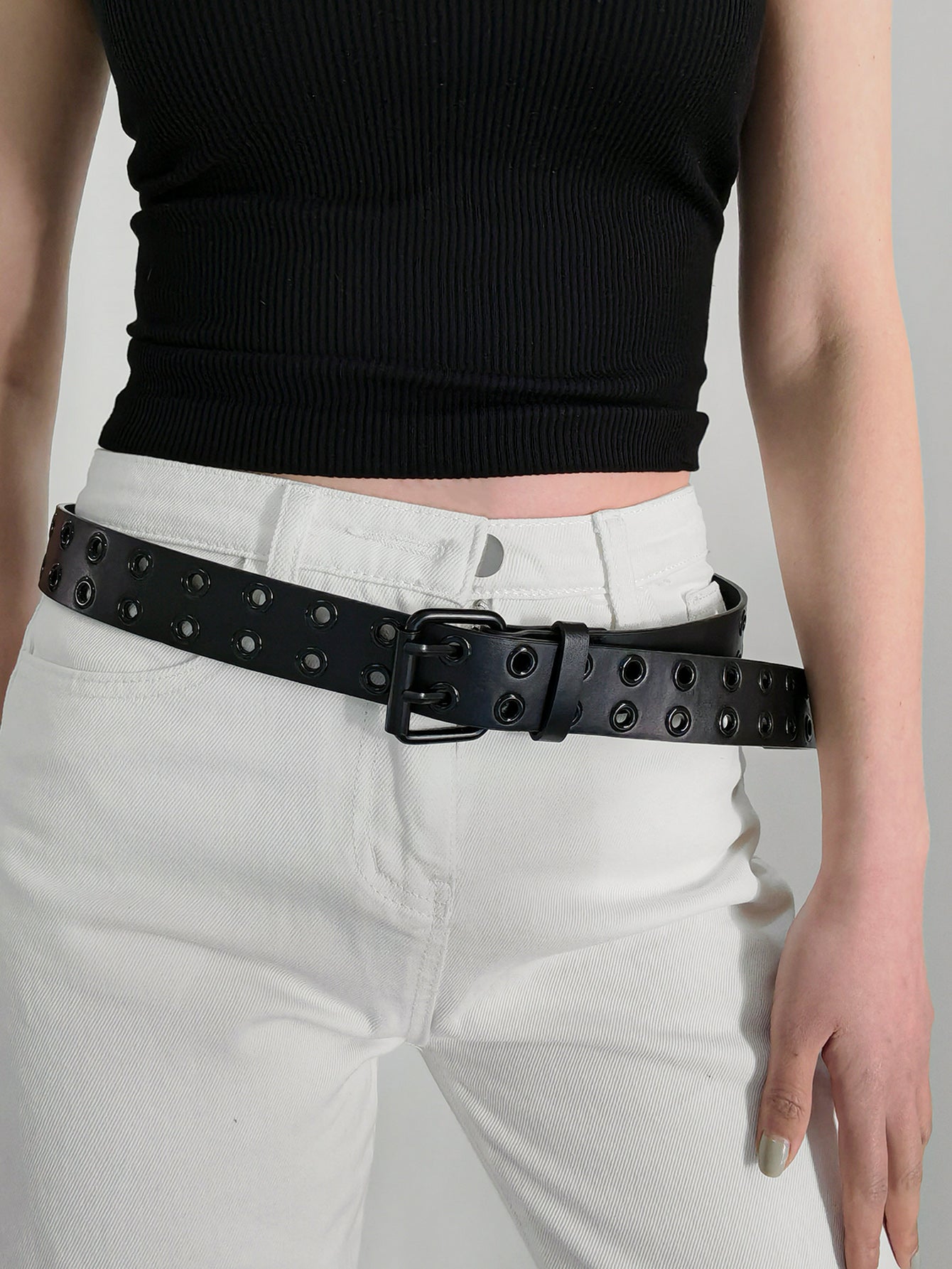 Black vegan leather grommet belt on waist with square buckle and eyelet studs