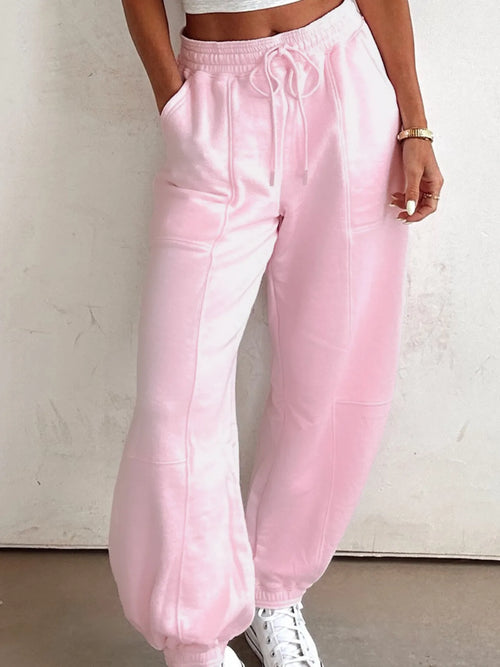 Pink drawstring sweatpants with elastic waist and side pockets