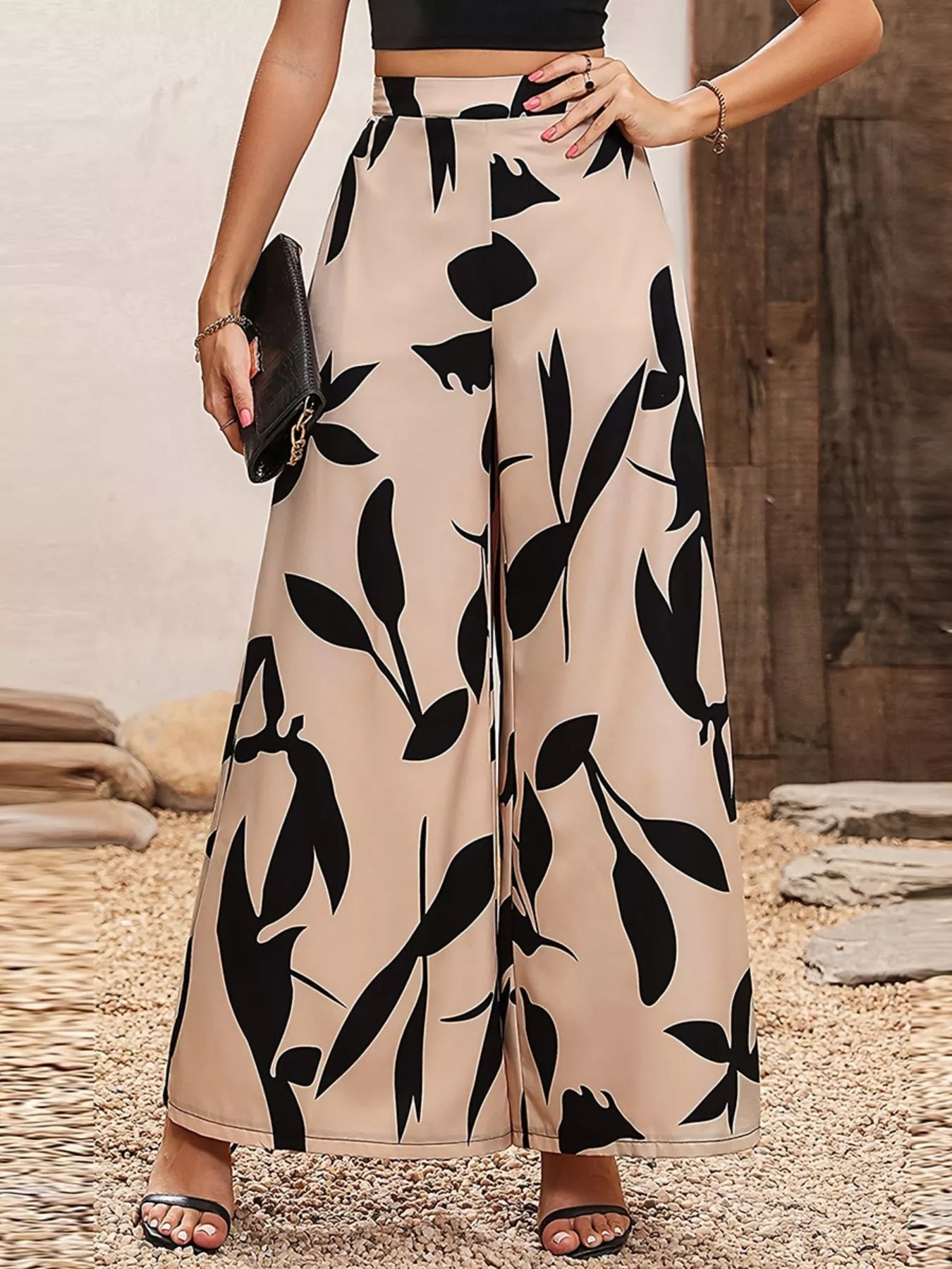 Printed wide-leg pants in tan with large black foliage shapes, relaxed straight legs.