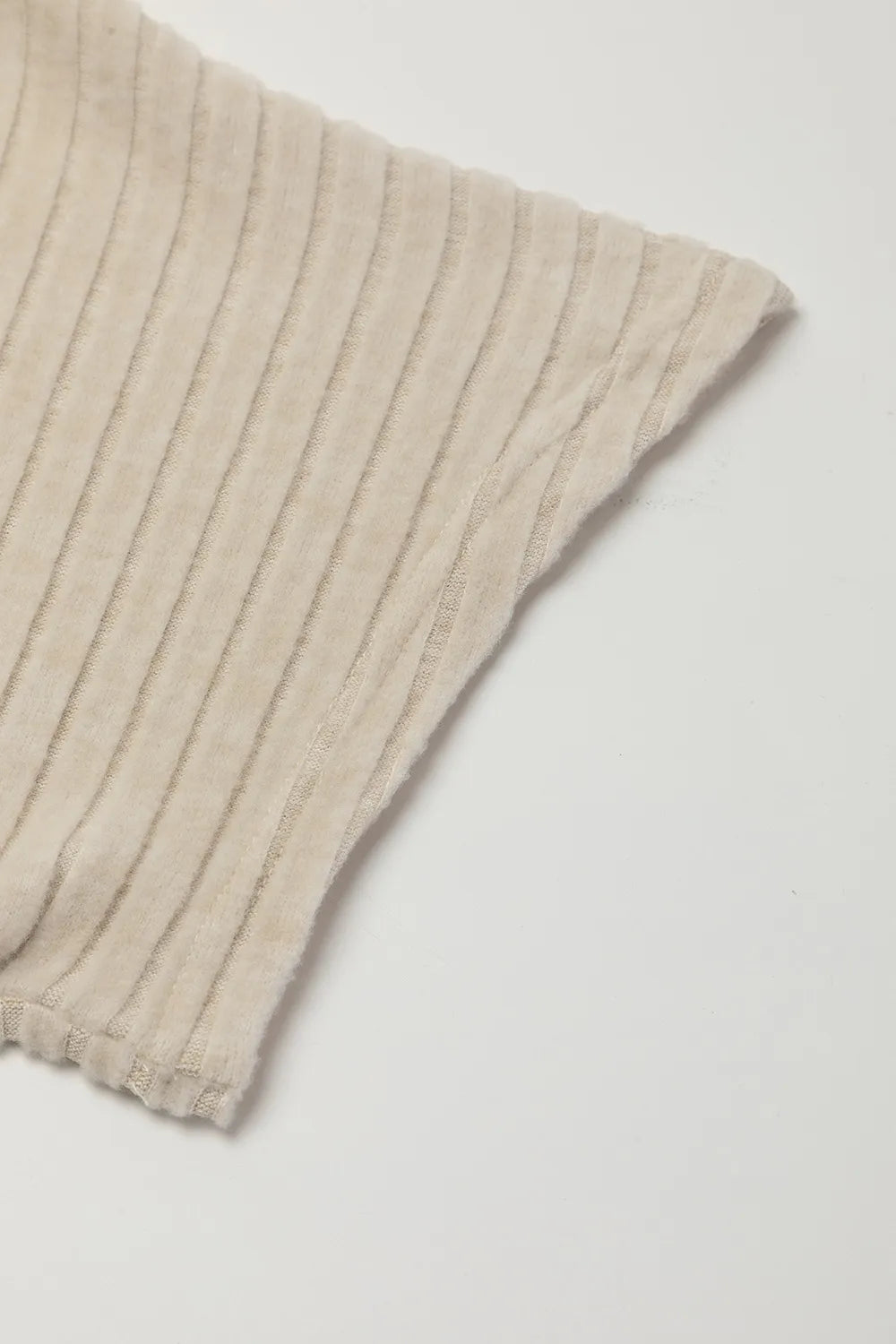 Beige ribbed knit jumpsuit sleeve cuff detail with vertical rib texture
