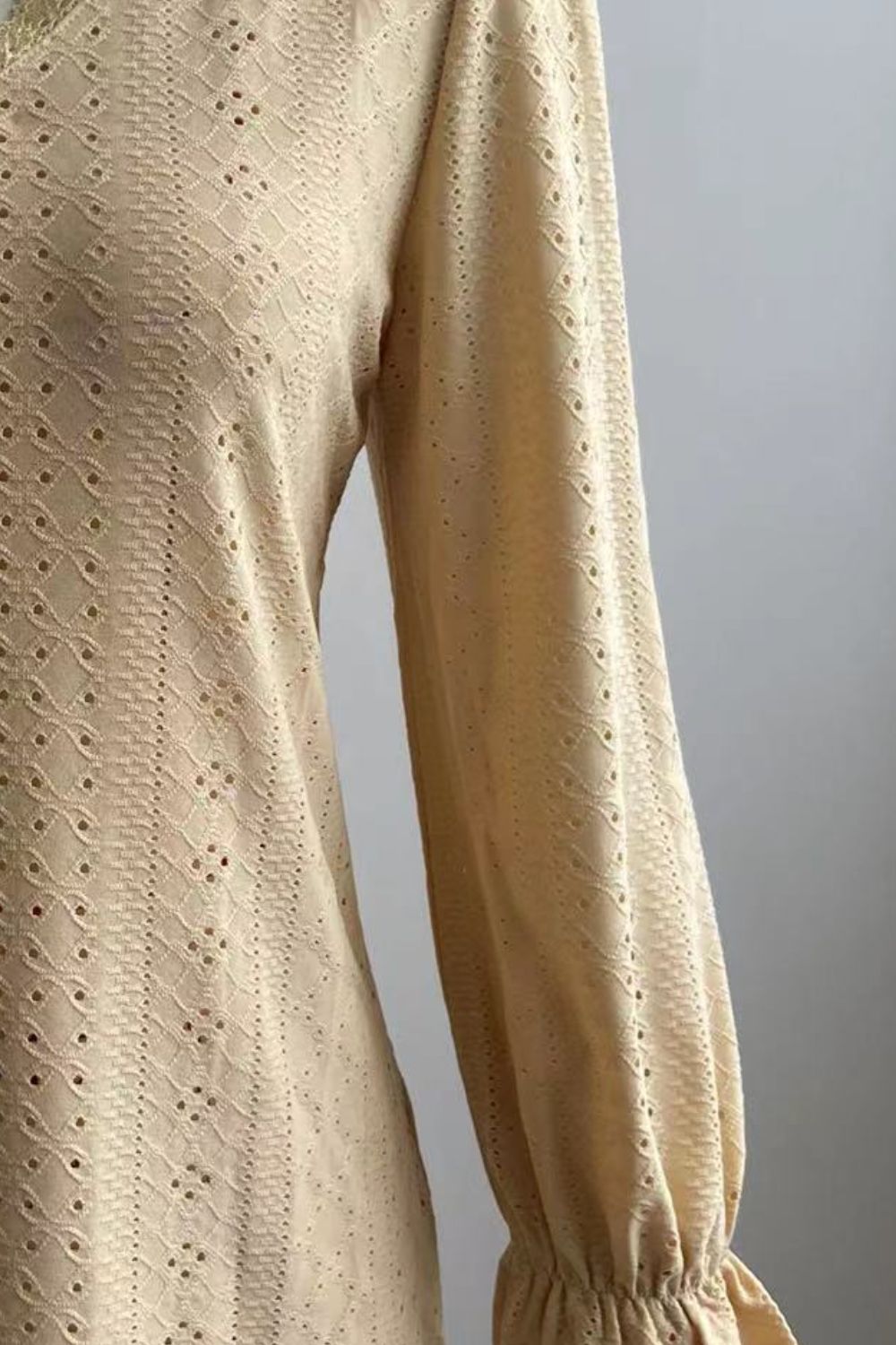 Ivory eyelet blouse fabric detail with small perforated pattern