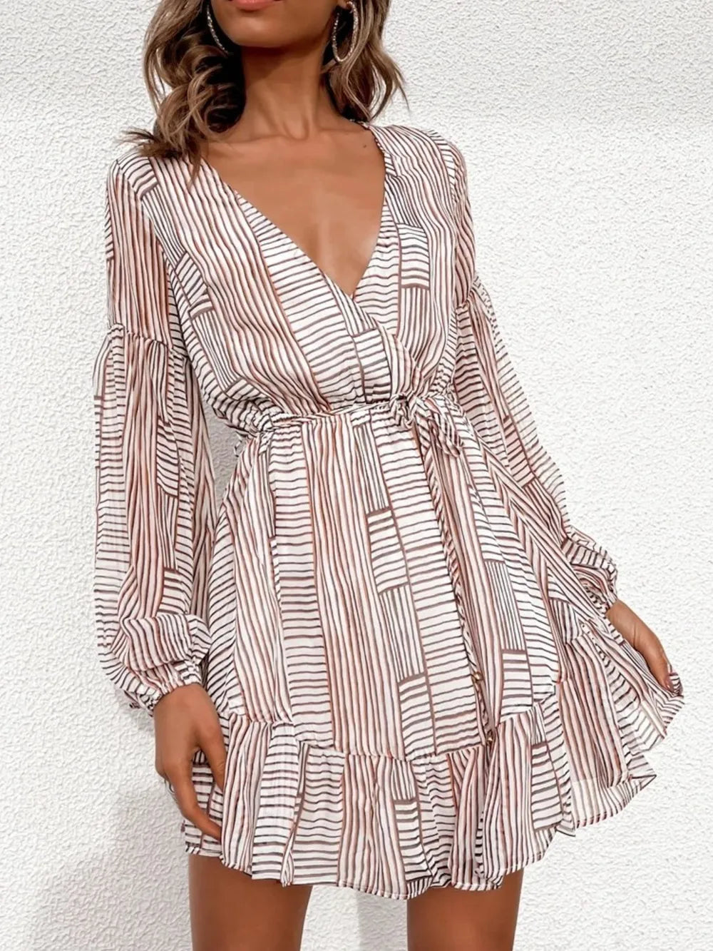 Camel-and-white striped long-sleeve surplice dress with V-neck and tiered ruffle hem