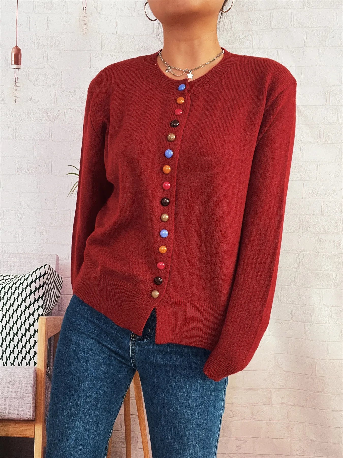 Red button-front cardigan with long sleeves and a vertical row of colorful accent buttons