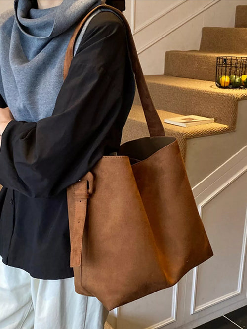Brown tote bag with buckle-adjustable strap, open top, soft structured body