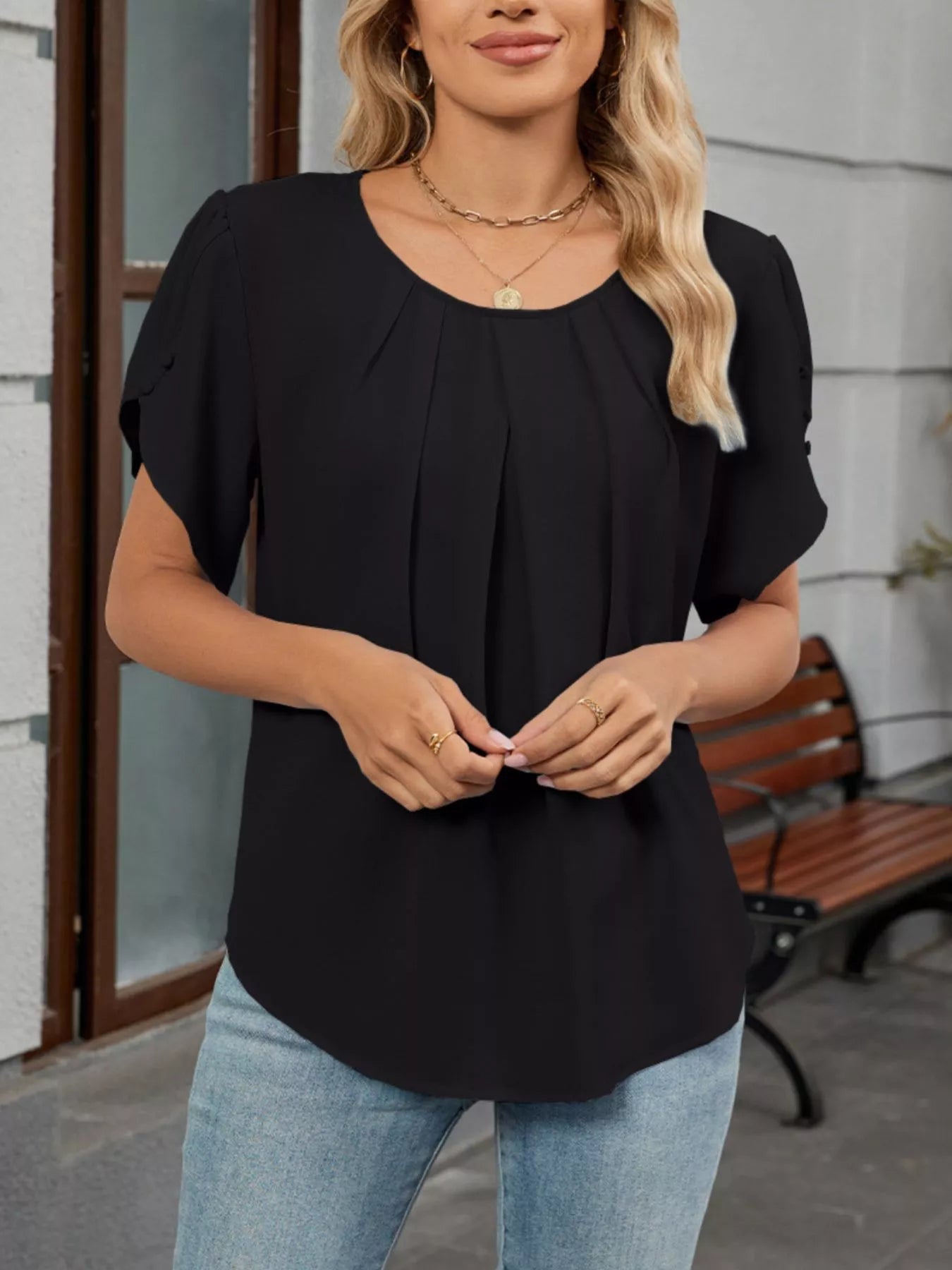 Black pleated flowy short-sleeve blouse with round neckline and gathered front