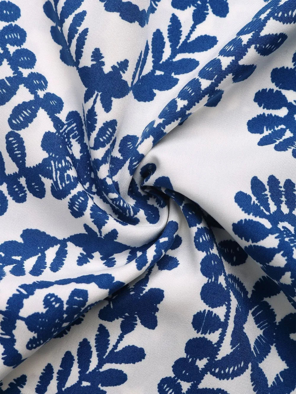 White fabric with blue floral print, woven texture visible